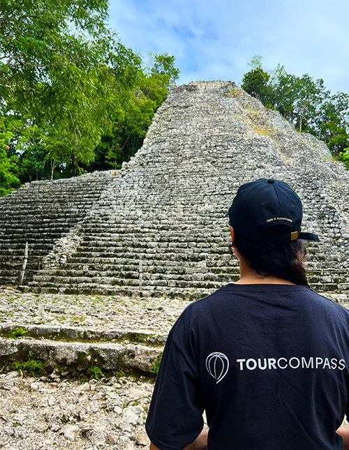 En person i TourCompass-genser står foran en maya-ruin i Mexico