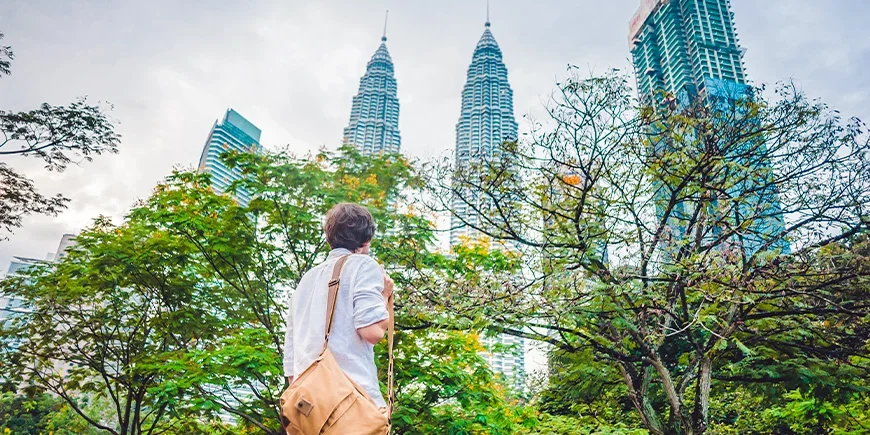 Mann som ser på Petronas Twin Towers i Kuala Lumpur i Malaysia