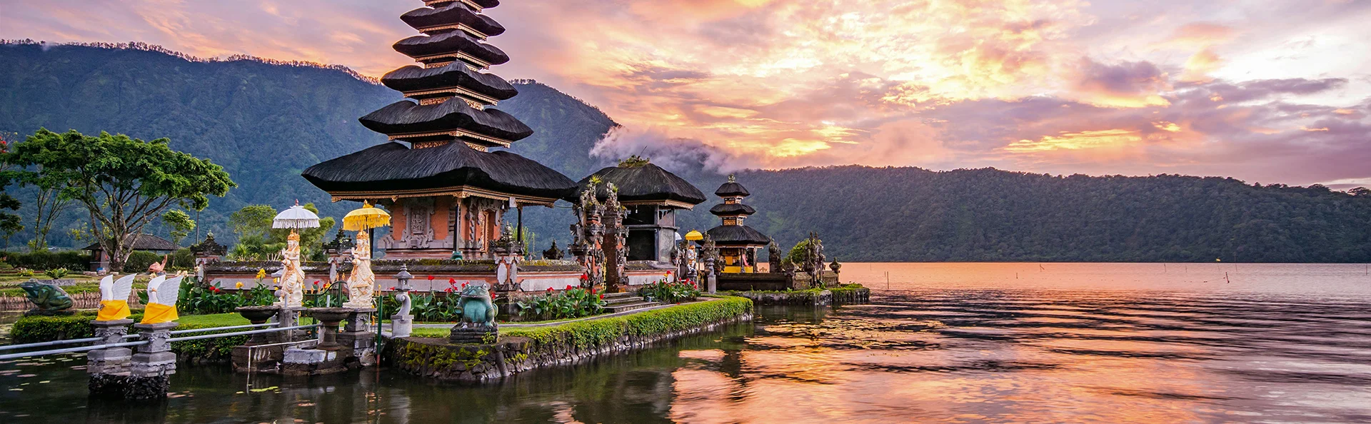 Vakkert tempel ved en innsjø i solnedgang på Bali