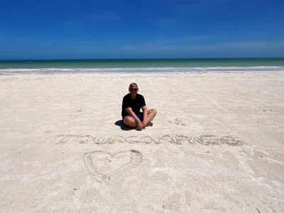 Tom sitter i sanden på Isla Holbox i Mexico