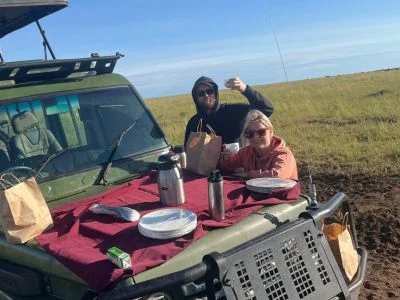 To personer spiser frokost i safaribilen