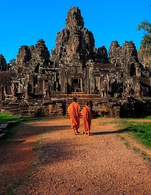 Munkene blant Bayon-tempelets eldgamle steinansikter, Angkor, Kambodsja