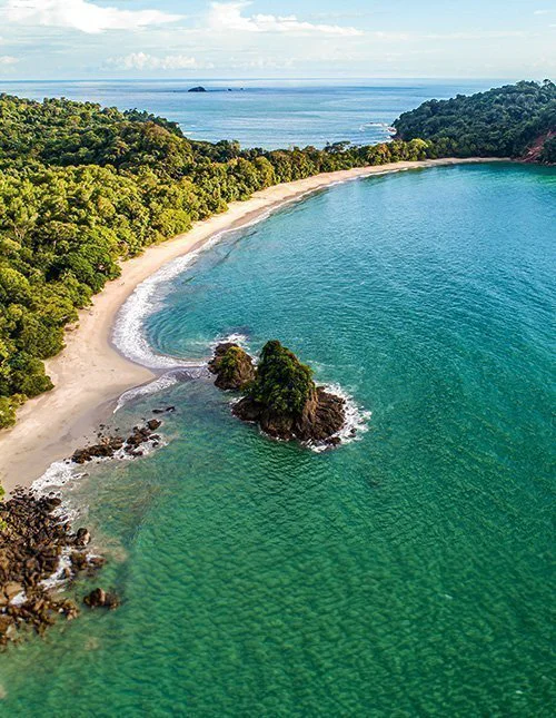 Luftfoto av den tropiske Espadilla-stranden og kysten ved Manuel Antonio nasjonalpark