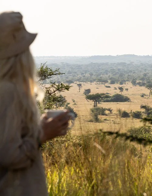 Kvinne skuer ut over savannelandskapet
