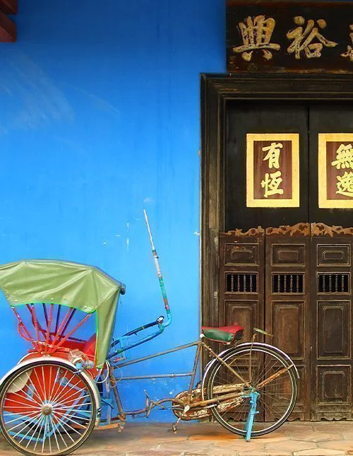 Blå kinesisk husdør med en rickshaw i Singapore